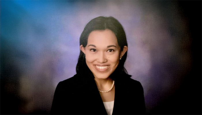 A color photo of a woman smiling for a portrait.