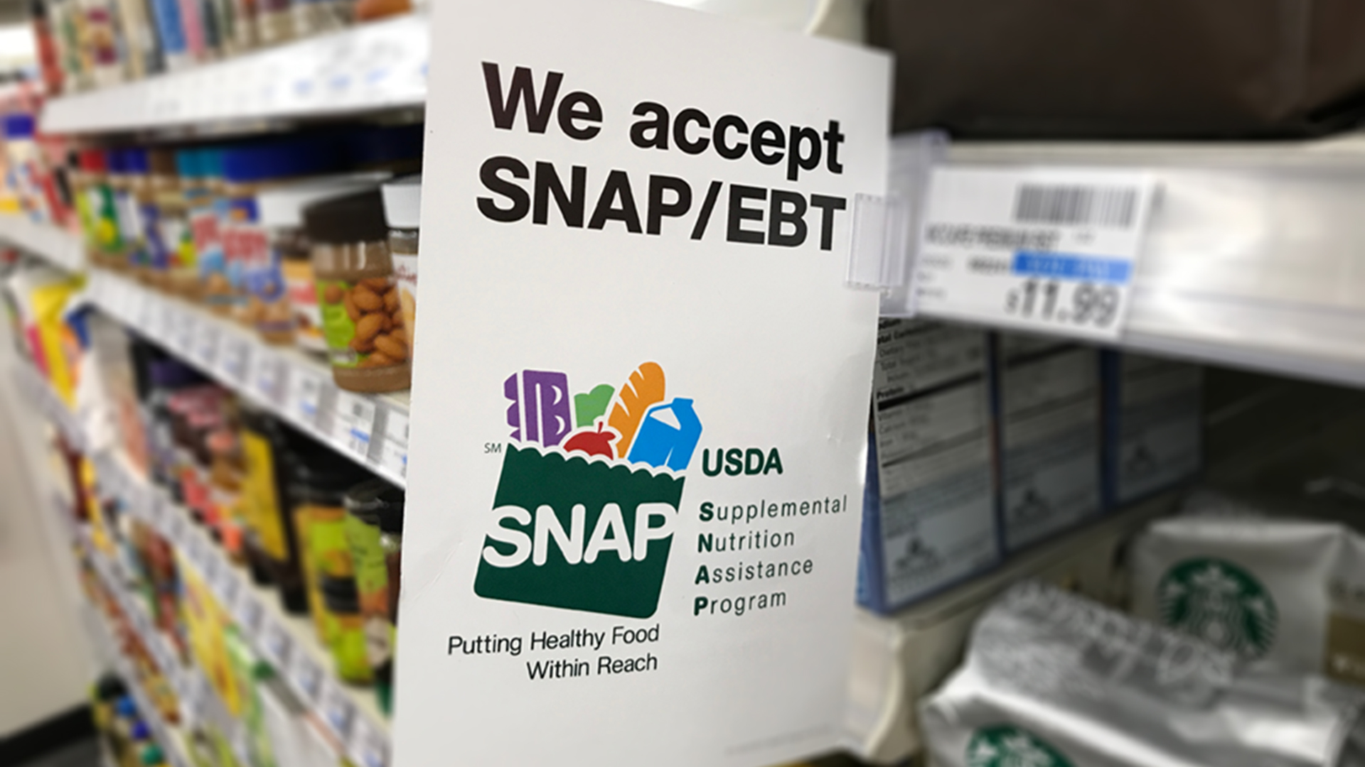 A color photo showing a sign for SNAP at a grocery store. Shutterstock