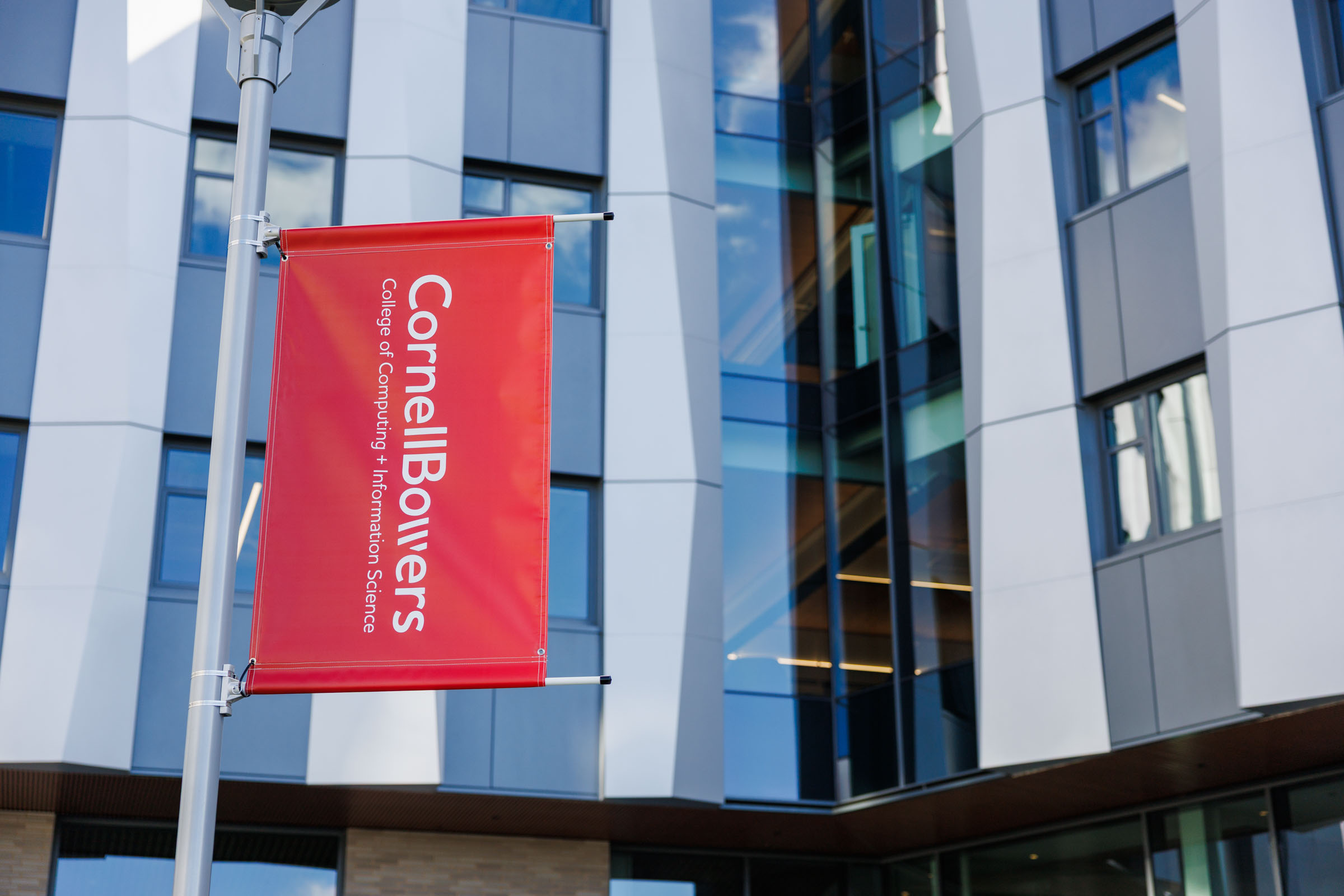 A color photo showing a red banner with the Cornell Bowers logo in white.