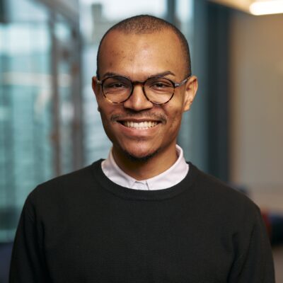 A color photo of a man smiling for a photo.