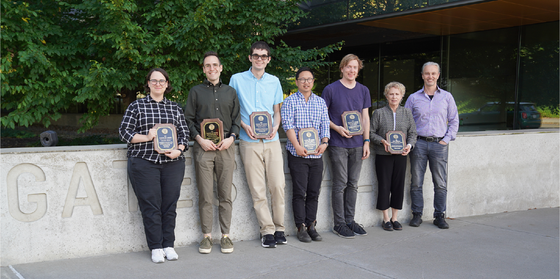 A color photo showing the faculty award winners with their plaques.