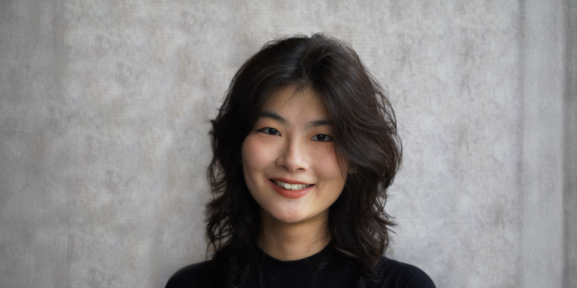 A color photo of a woman smiling for a photo.