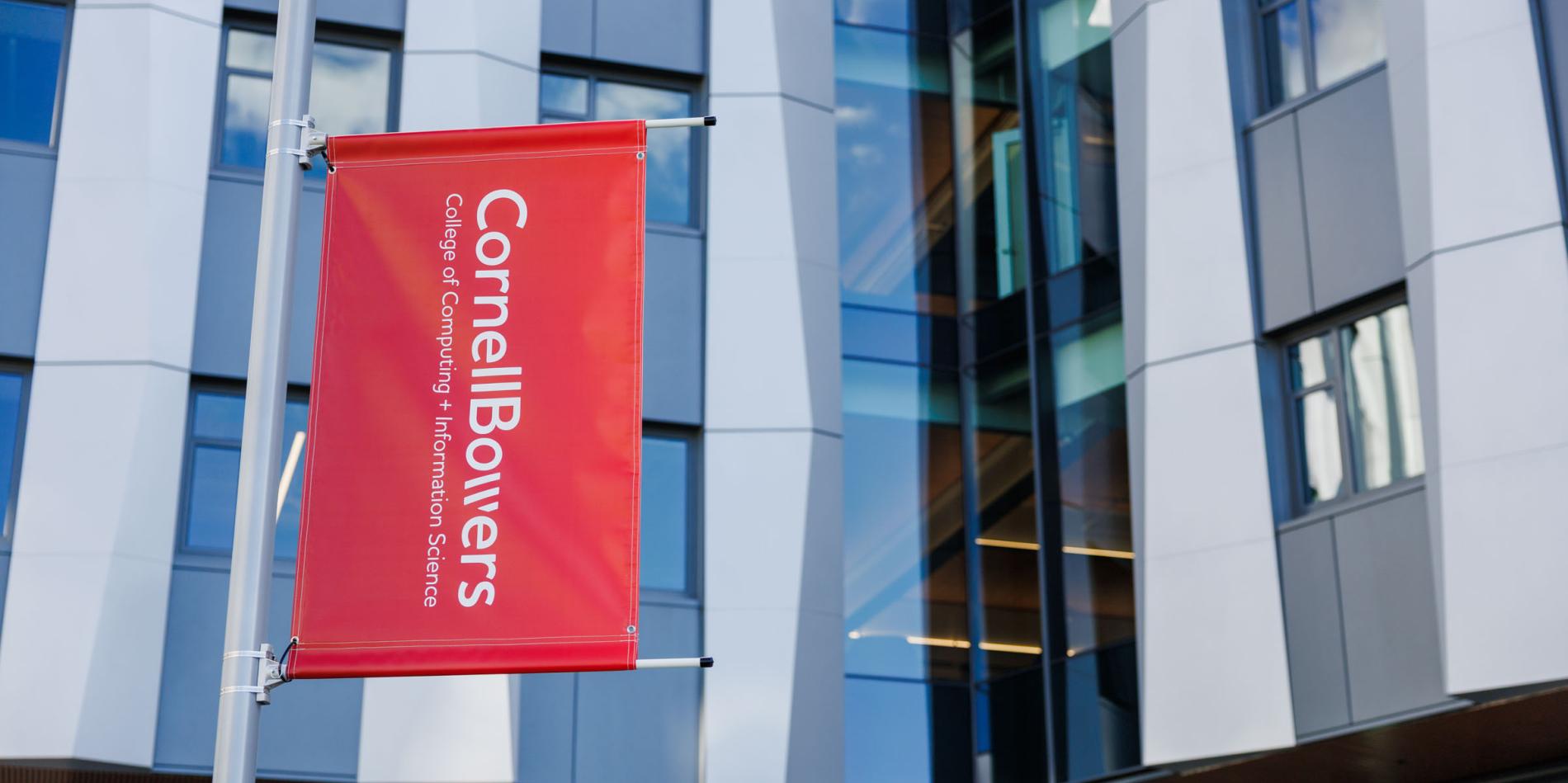 A color photo showing a red banner with the Cornell Bowers logo in white.