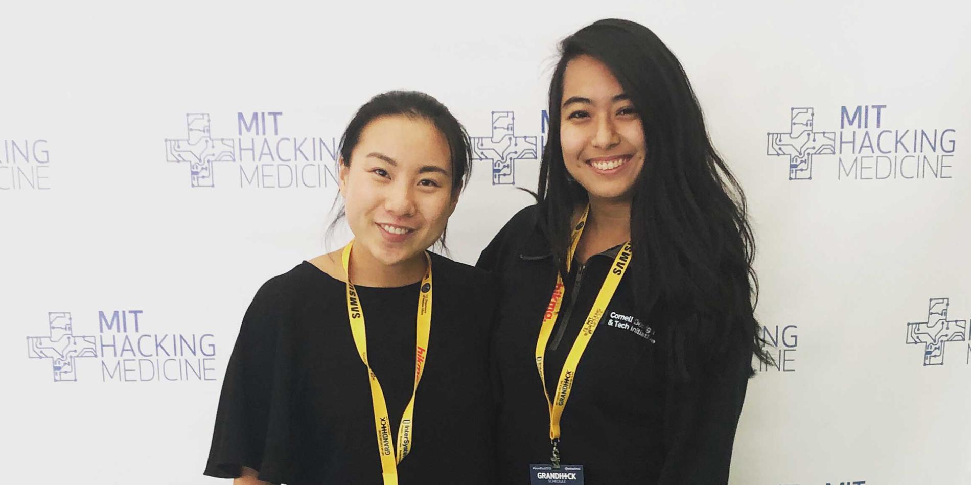 A color photo of 2 women smiling for a photo.