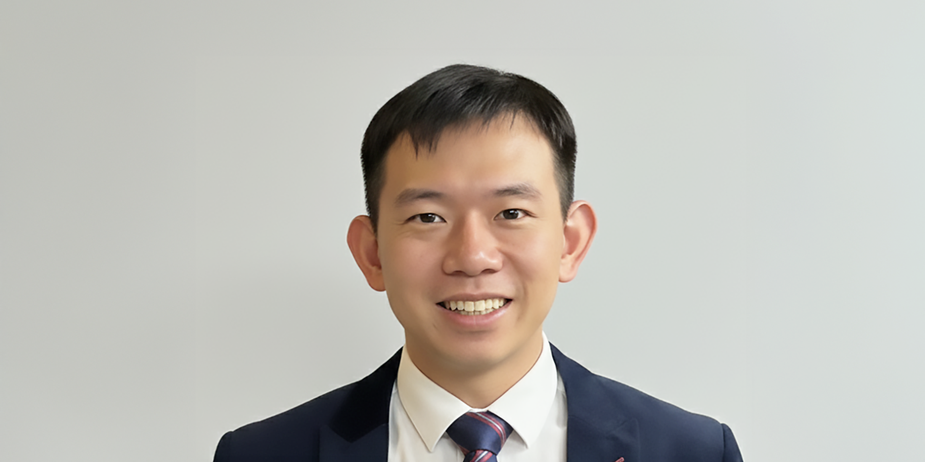 A color photo of a man wearing a suit and tie.