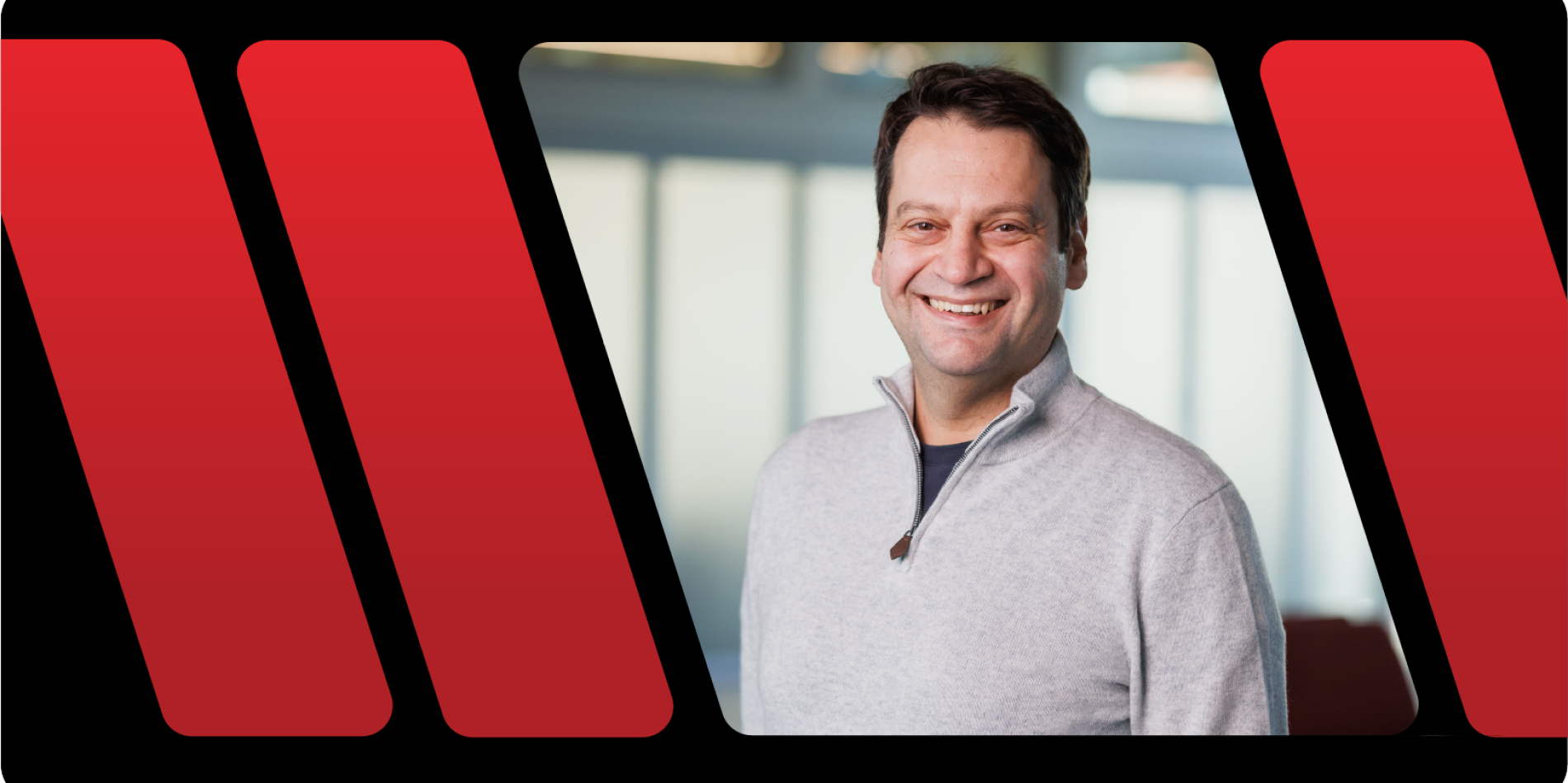 A color photo of a man smiling for a photo.