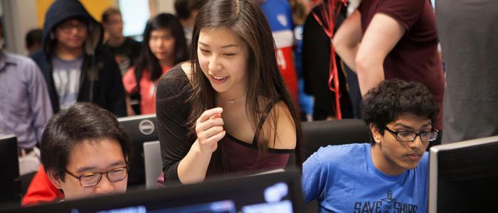 Students gathered around computers at a campus event.