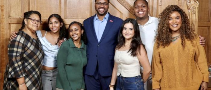DEIB staff in front of a wood panel wall