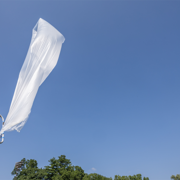 A color photo showing a weather balloon about to take flight.
