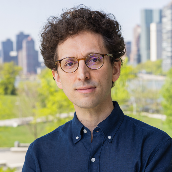 A color photo of Yoav Artzi infront of a city park background