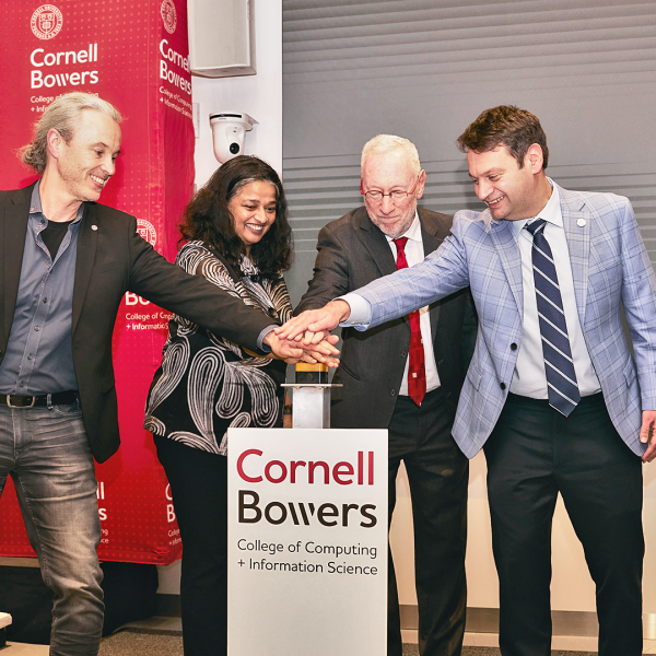A color photo showing a group of people pushing a button at a building dedication.