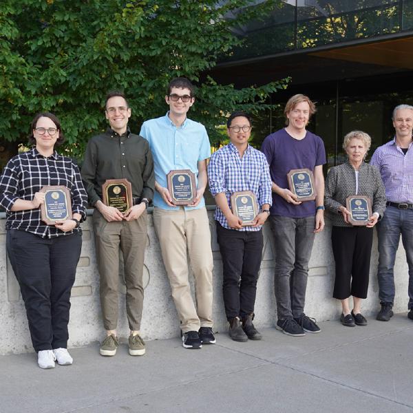 A color photo showing the faculty award winners with their plaques.