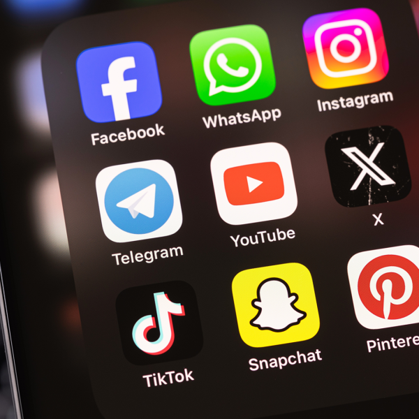 A color photo of a smart phone with social media icons.