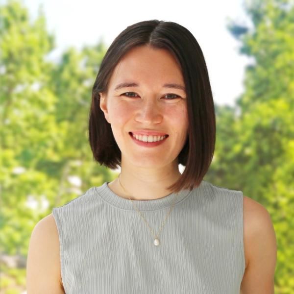 A color photo of a woman smiling for a photo.