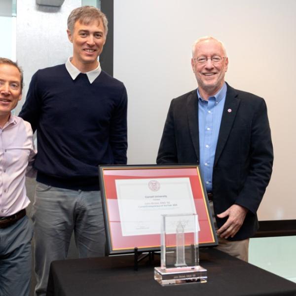  John Bicket ’02, center, receives the Cornell Entrepreneur of the Year award from Zach Shulman ’87, J.D. ‘90, director of Entrepreneurship at Cornell, left, and Cornell President Michael Kotlikoff.
