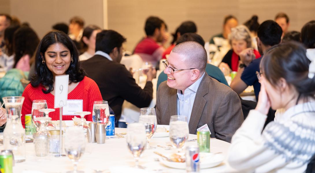 Michael Clarkson laughs with students at dinner.