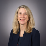 A color photo of Laura Batten in front of a grey background