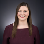 A color photo of Laura Schad in front of a dark background