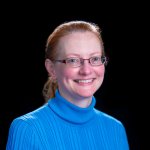 A color photo of Erin Pyrek in front of a black background