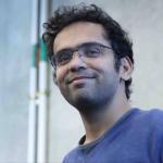 A photo of Sanjiban Choudury, a man with dark hair and glasses in a blue shirt.