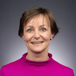 A photo of Anke van Zuylen, a woman with short brown hair in a pink shirt.