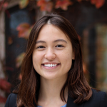 A color photo of a woman smiling for a photo.