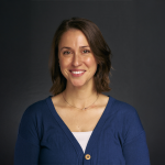 A color photo of a woman smiling for a photo.