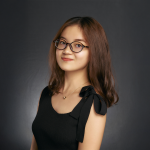 A color photo of a woman smiling for a photo.