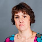 Color photo of woman with chin length brown hair