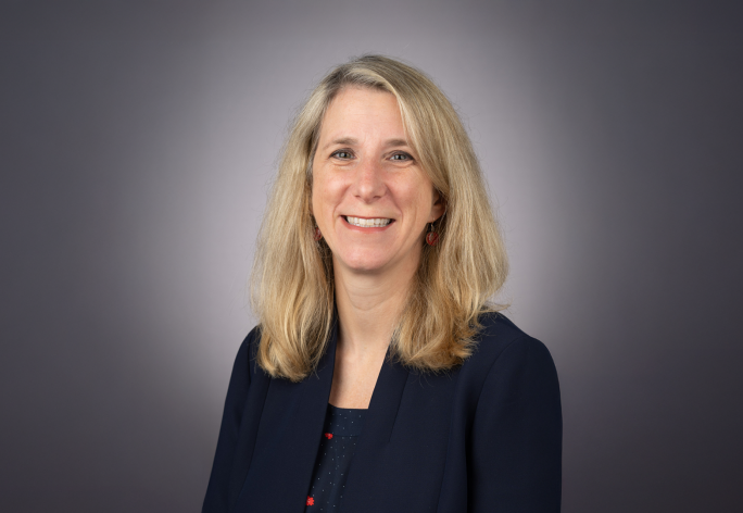 A color photo of Laura Batten in front of a grey background