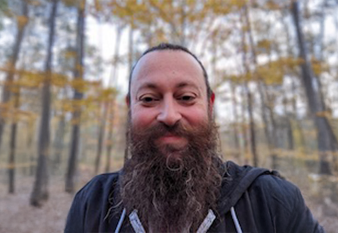 A color photo of Matt Thomas in the woods