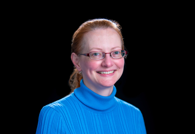 A color photo of Erin Pyrek in front of a black background