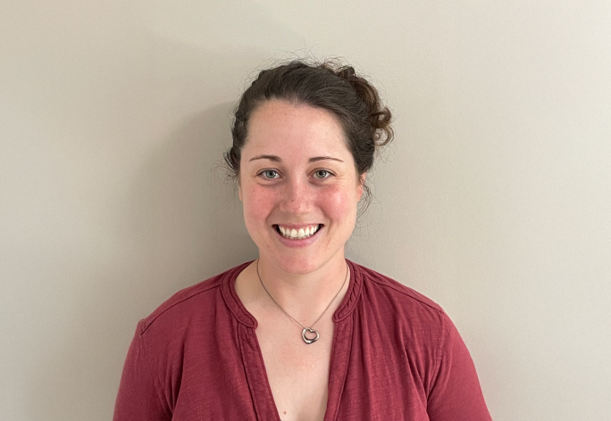 A color photo of Rebecca Dillon in front of an off-white background