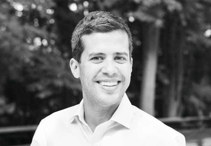 A black and white photo of Ryan Marchenese standing outside