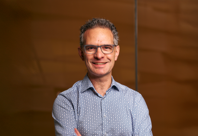 A photo of Stephen Marschner, a smiling man in front of a brown background