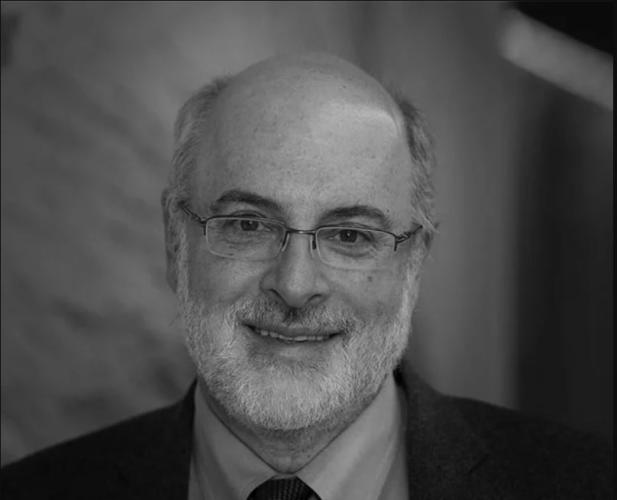 A black and white photo of Kenneth Birman, a man with glasses wearing a suit and tie.