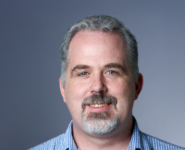 Aphoto of Walker White, a smiling man with short gray hair, a mustache, goatee and a blue check shirt. 