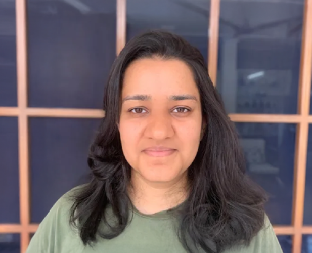 A photo of Tanya Goyal, a woman with shoulder-length dark brown hair in a green shirt.
