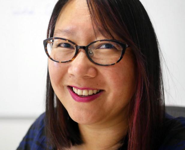 Woman in glasses smiling at camera, 