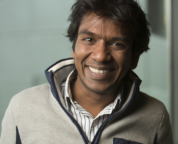 The head and shoulder of a man with black hair and a gray fleece.