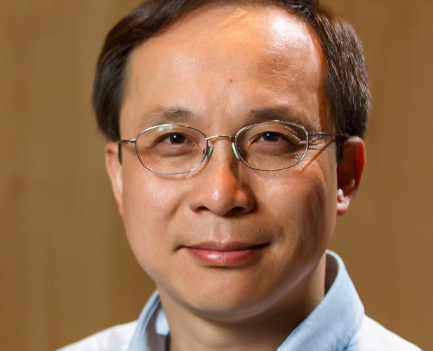 portrait of man with dark hair and glasses