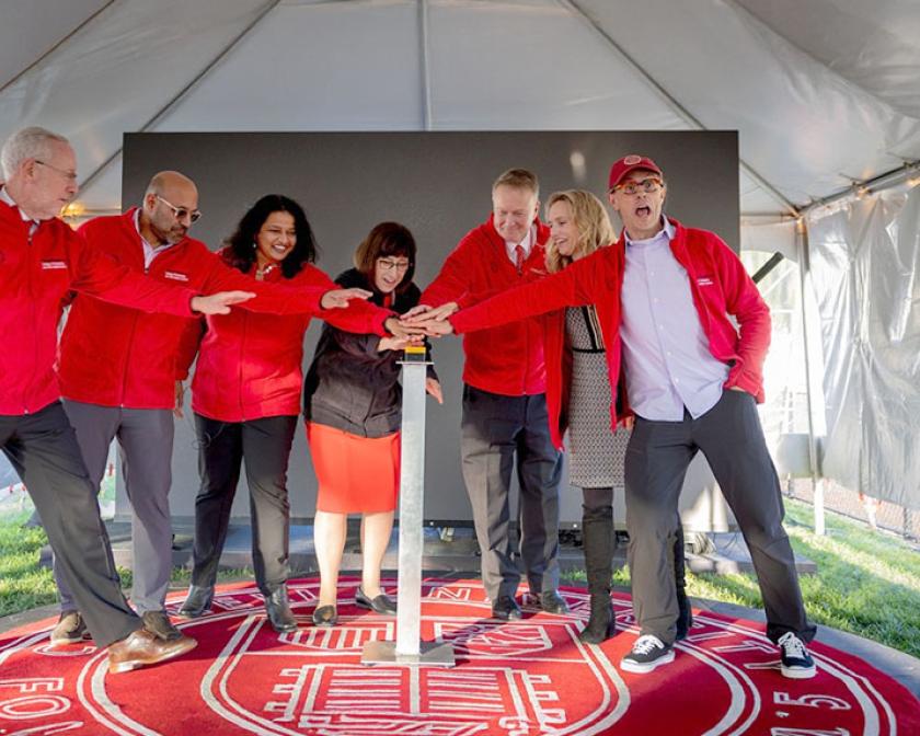 Group celebrates new Bowers CIS building with ceremonial button push under event tent.