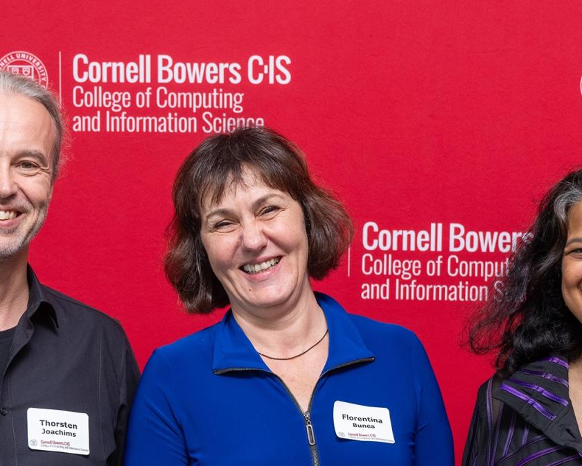 Woman with short hair looking at camera, wearing blue blouse with green scarf