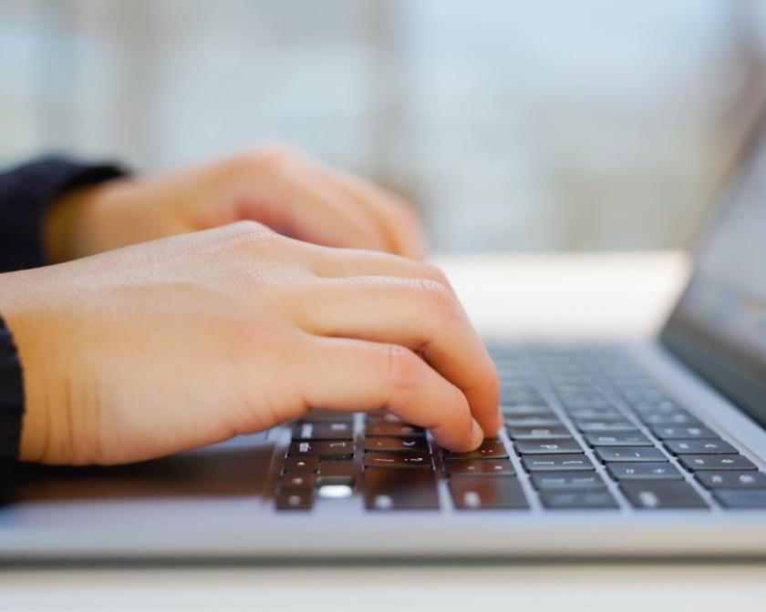 hands typing on a laptop