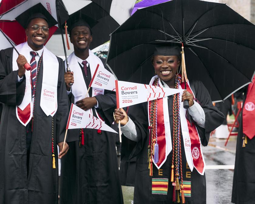 a group of black graduates smile under their umbrellas during the procession