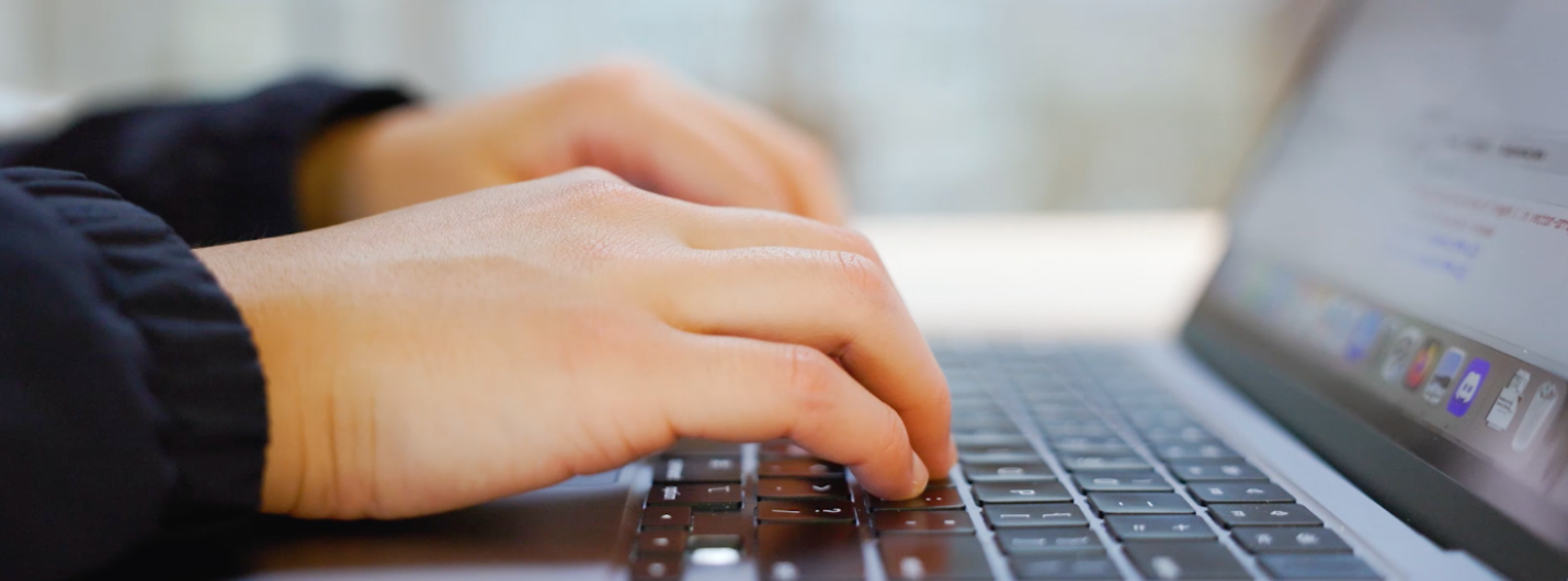 hands typing on a laptop