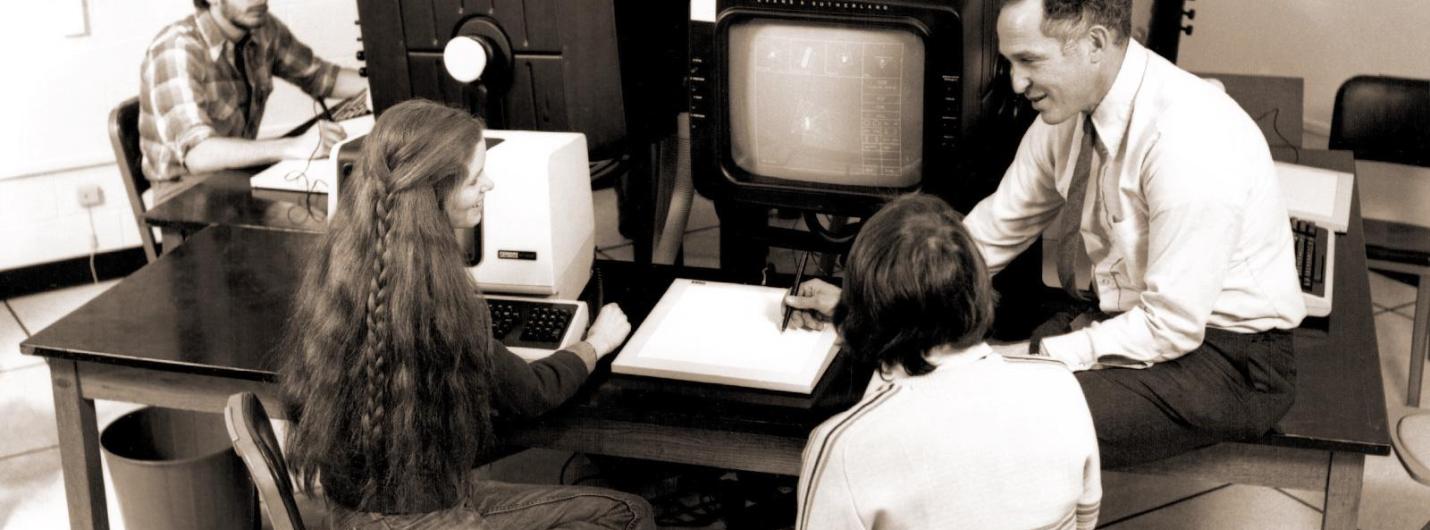 black and white photo of students and male professor working on early computers