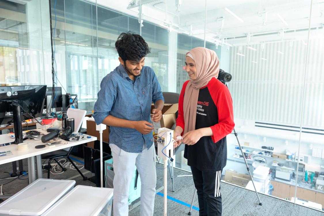 two students work on a cane tech device inside a classroom