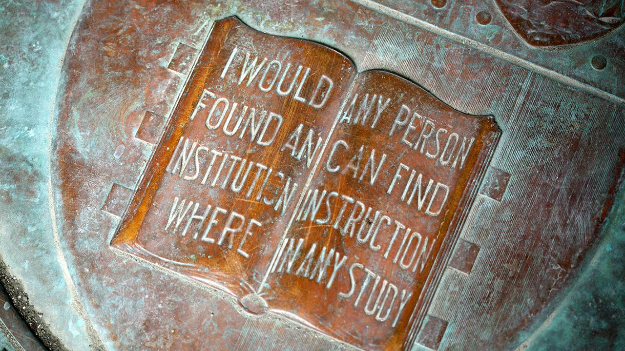 a book on a reads "i would found an institution where any person can find instruction in any study."